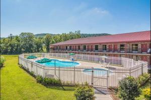 a building with a swimming pool in a yard at Econo Lodge Fort Payne in Fort Payne