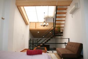 a room with a staircase and a bed and a chair at Casa Ramon y Cajal Alcañiz in Alcañiz