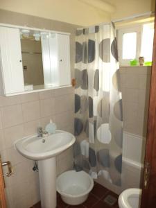 a bathroom with a sink and a toilet and a shower at New Apartment Tsouris ~Makrys Gialos~ in Makry Gialos