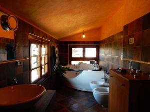 y baño con bañera, 2 lavabos y bañera. en Villa Angelinas, en Monte San Savino