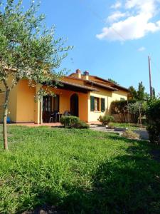 una pequeña casa amarilla con césped delante en Villa Angelinas, en Monte San Savino
