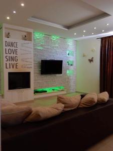 a living room with a couch in front of a tv at Villa Angelinas in Monte San Savino