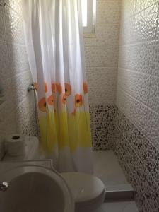 a bathroom with a toilet and a shower curtain at Stefanel View-Frederika in Himare