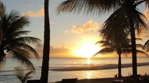 a sunset view of a beach with palm trees at Camauí Hotel in Barra Grande