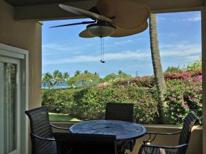 a patio with a table and chairs and a window at Beach Villas at Kahalu'u in Kailua-Kona