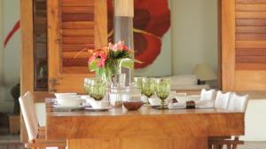 a wooden table with a vase of flowers on it at Camauí Hotel in Barra Grande