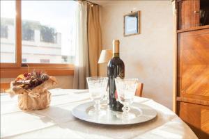 una bottiglia di vino seduta su un tavolo con bicchieri di Amazing panoramic artitst's loft Spanish Steps a Roma
