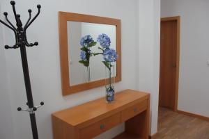 un jarrón de flores azules en un tocador en una habitación en A Casa Sousa, en Ginetes