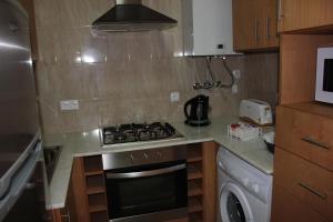 a small kitchen with a stove and a microwave at A Casa Sousa in Ginetes