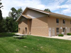 ein Gebäude mit einem Picknicktisch im Gras in der Unterkunft Oakridge Motel in Newaygo