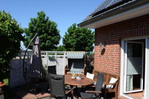 eine Terrasse mit Tisch und Stühlen und einem Sonnenschirm in der Unterkunft Ferienhaus 8erwassereck in Ückeritz