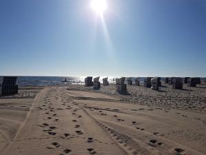 einen Strand mit Stühlen und Fußabdrücken im Sand in der Unterkunft Ferienhaus 8erwassereck in Ückeritz