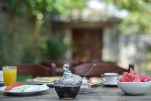 einen Tisch mit Teller mit Lebensmitteln und eine Schale mit Obst in der Unterkunft Hotel Kalemi in Gjirokastër