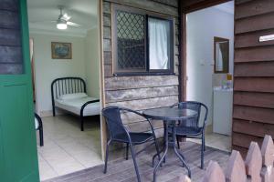 a patio with a table and chairs and a window at Woolshed Eco Lodge in Hervey Bay