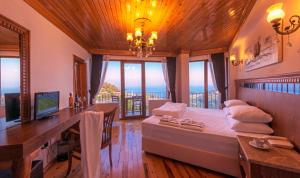 a bedroom with a desk and a bed with a view at Assos Kayalar Terrace in Sazlı