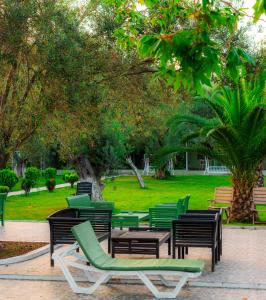 um grupo de cadeiras verdes e mesas num parque em Kayalar Blue Beach Hotel em Sazlı