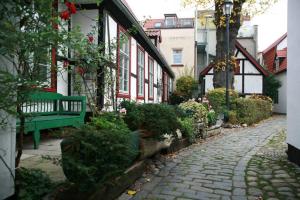 a cobblestone street with a green bench next to a building at Kurpark-Oase in Warnemünde