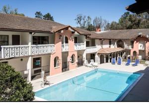 una gran piscina frente a una casa en La Casa Inn and Suites, en Tallahassee
