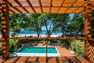 uitzicht op het zwembad vanaf de patio van een resort bij Flat Pitanga in Camburi