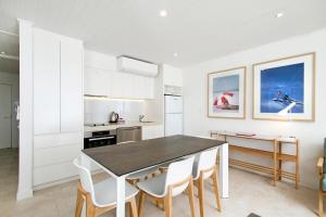 a kitchen with a dining room table and chairs at Fairshore Apartment 15, Noosa Heads in Noosa Heads