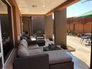 un soggiorno con divano e sedie di City Lodge Etosha a Omuthiya