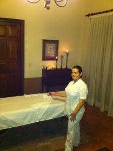 a woman standing next to a bed in a room at Santa Elena Hotel Boutique in Mascota