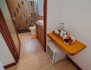 a bathroom with a sink and a bowl of fruit on a counter at Kaen Apartments in Canggu