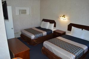 a hotel room with two beds and a television at Sands Motel Niagara Falls in Niagara Falls