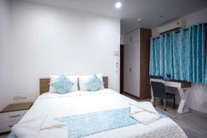 a bedroom with a large bed and a desk at LeBlanc Saigon in Ho Chi Minh City