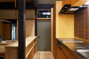 a kitchen with wooden cabinets and a door in it at Marukyo Gakurin-an in Kyoto