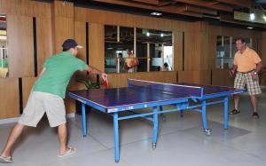 deux hommes jouant au ping-pong sur une table dans l'établissement The Cliff Resort & Residences, à Mui Ne