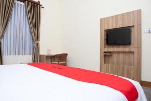 una camera da letto con un letto e una TV a schermo piatto di RedDoorz Plus near Pasundan University a Bandung Altre 36 foto