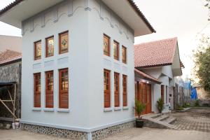 Casa blanca con ventanas con persianas rojas en RedDoorz Plus near Pasundan University, en Bandung