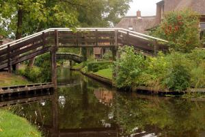 a bridge over a body of water at Hotel de Harmonie in Giethoorn
