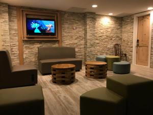 a living room with couches and tables and a tv at Ala Moana Motel & Suites in Wildwood