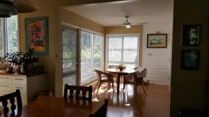 una sala da pranzo con tavolo, sedie e finestre di Glenburn House a OʼConnell