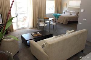 a living room with a couch and a bed at Mollymook Cove Apartments in Mollymook