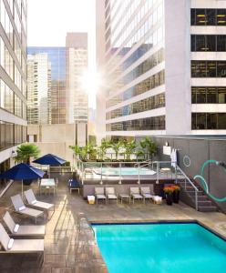 a pool with chairs and umbrellas in front of a building at Hyatt Regency Vancouver in Vancouver