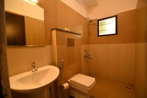 a bathroom with a sink and a toilet at Lake View Hotel in Madurai
