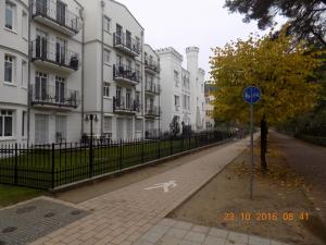 a person walking down a street in front of buildings at Appartment Ostseetraum in Ahlbeck