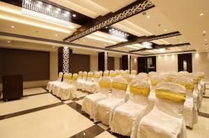 a room with rows of chairs with white linens at Hotel Vista Inn in Navi Mumbai