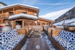 a log cabin in the snow with couches on a deck at Chalet Du Friolin in Les Coches