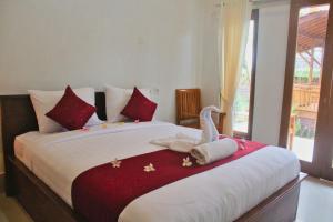 Un dormitorio con una cama con un cisne. en Swan Beach Inn, en Nusa Penida