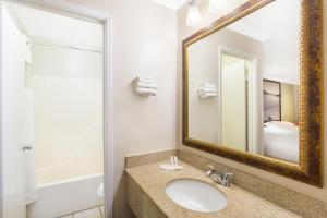 ein Bad mit einem Waschbecken und einem Spiegel in der Unterkunft Upper Lake Inn & Suites in Upper Lake