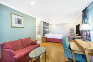 ein Wohnzimmer mit einem Sofa und einem Bett in der Unterkunft Upper Lake Inn & Suites in Upper Lake