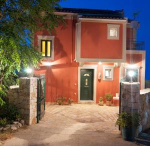 una casa rossa con una porta verde di notte di superb villa with private pool peaceful location a Sami