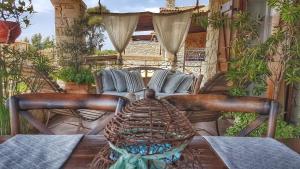 a wooden table with a couch on a patio at Luxurious Stone House in Elani in Siviri