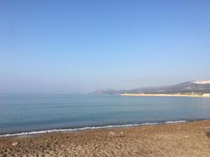 a beach with the ocean and mountains in the background at İskele Otel in Tasucu