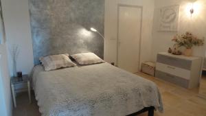 een slaapkamer met een bed met 2 kussens erop bij Les Chèvrefeuilles in Manosque