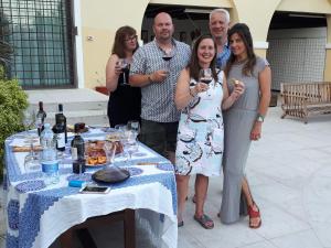 een groep mensen die rond een tafel met wijnglazen staan bij Two Elegant Depandance in Conscio
